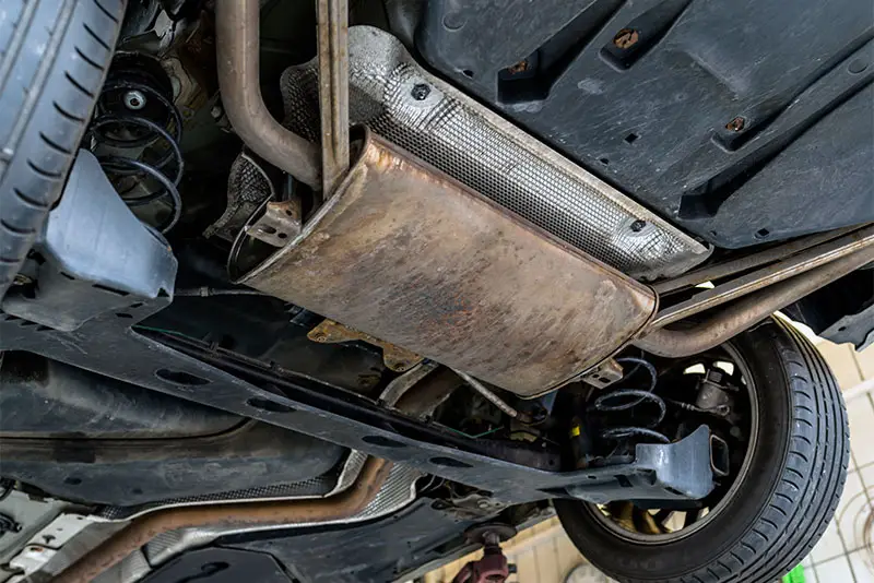 Old catalytic converter underneath a car