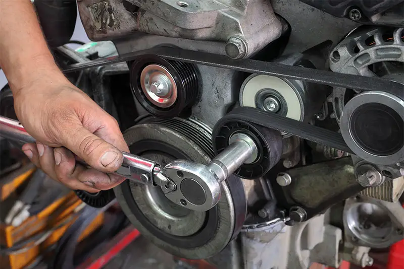 Digital torque wrench being used to tighten an engine belt.