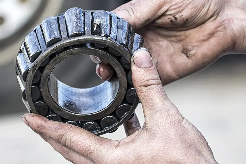 Mechanic holding a bad wheel bearing in his hands